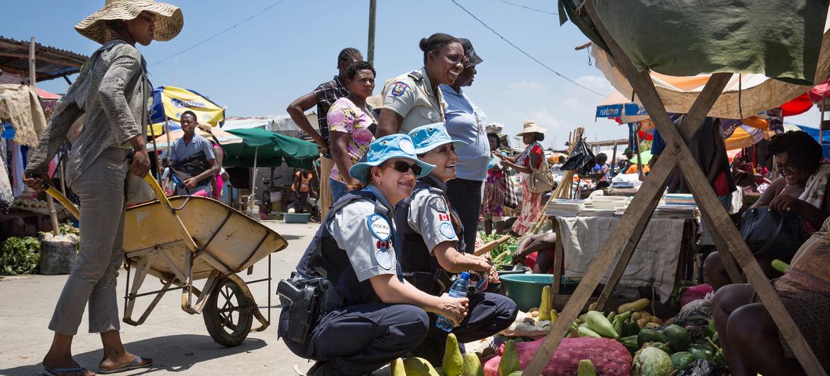 Dua petugas polisi Kanada yang bertugas dengan MINUGUSTH di Haiti berbicara dengan wanita setempat tentang upaya PBB untuk memerangi eksploitasi dan pelecehan seksual.