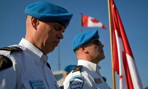 Des policiers canadiens en poste à la MINUSTAH pleurent leurs collègues Doug Coates et Mark Gallagher lors d'une cérémonie à Port-au-Prince, en Haïti. Tous deux ont été tués lors du tremblement de terre qui a frappé la capitale en janvier 2010.