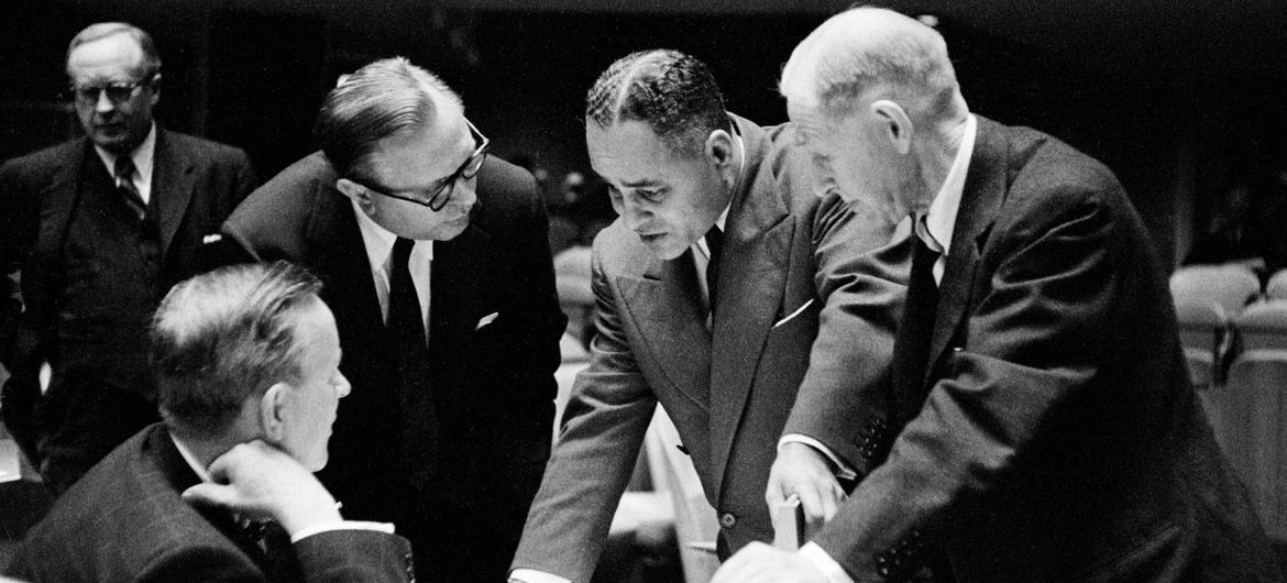 Lester B. Pearson, Secrétaire d'État canadien aux Affaires extérieures (assis à gauche) s'entretient avec le Secrétaire général adjoint des Nations Unies, Ralph J. Bunche, lors d’une session de l'Assemblée générale en 1956 pour établir une force de l'ONU 