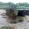 热带风暴“安娜”在莫桑比克登陆后，人们站在受损的桥上。