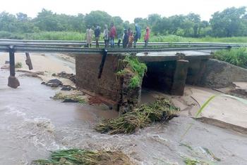 People stand on a damaged bridge in the aftermath of Tropical Storm Ana making landfall in Mozambique.
