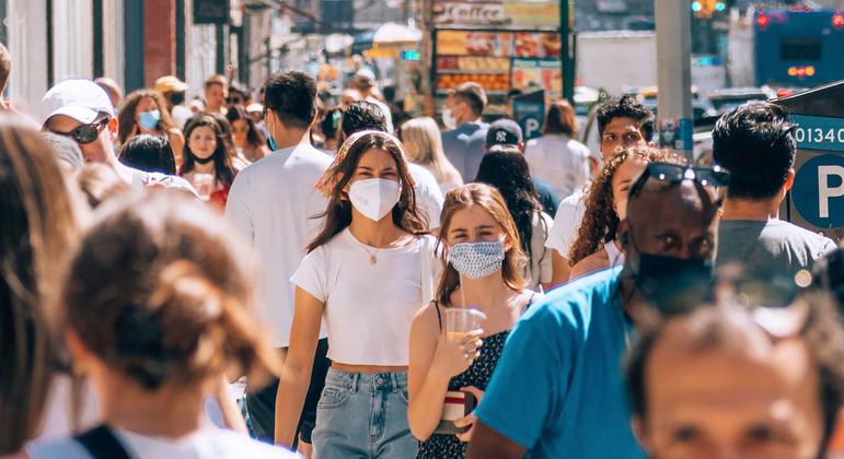 People walk on a busy street in a popular shopping district in Downtown Manhattan, New York.