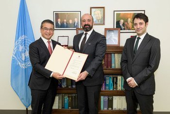 Edwin Tong Chun Fai (left) of Singapore presents instruments of ratification to UN Legal Counsel Miguel de Serpa Soares. At right is David Nanopoulos of the Office of Legal Affairs.