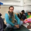 让-尼古拉斯在约旦阿兹拉克难民营的避难所与叙利亚难民瓦尔达和她的五个孩子交谈。