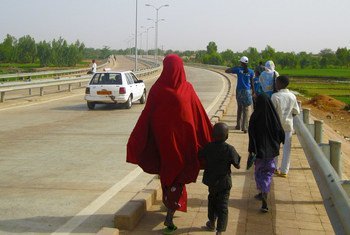 A family walks along a highway overpass in Niamey, Niger.