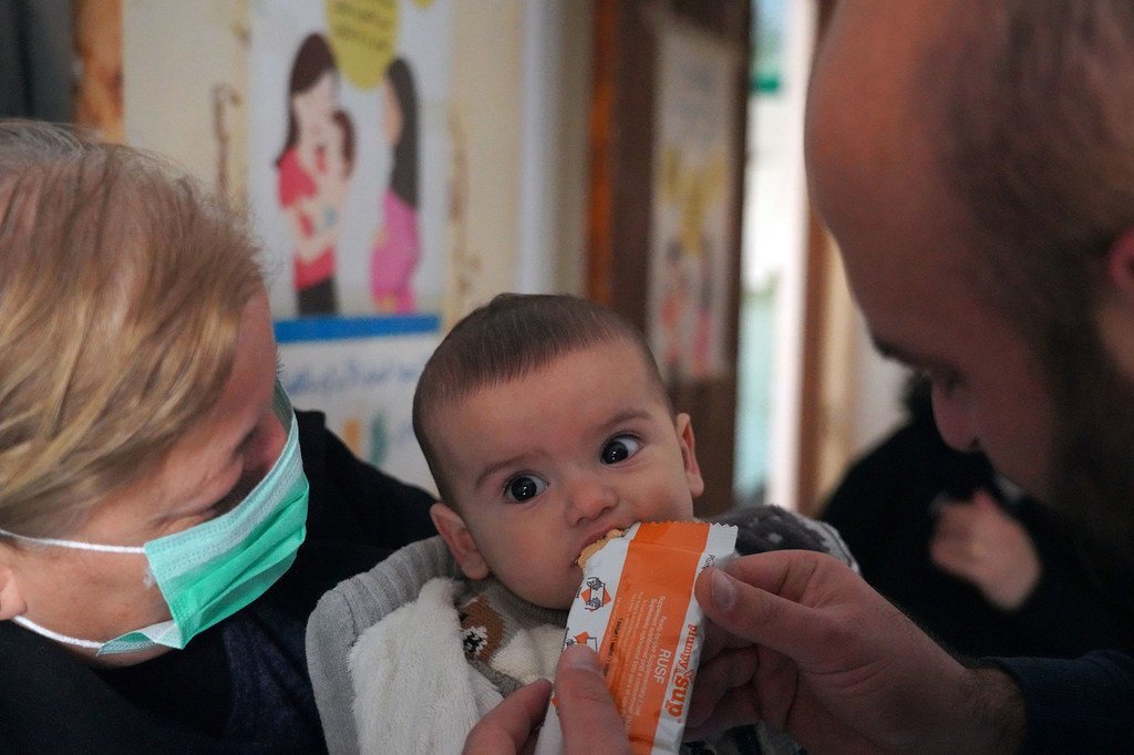 一个九个月大的婴儿在叙利亚塔尔图斯的一家诊所吃富有营养的花生酱。