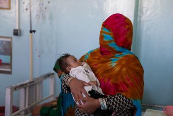 أم تحمل طفلها المصاب بسوء التغذية في مستشفى مرويس الإقليمي في قندهار ، أفغانستان.