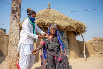 امرأة مسنة تتلقى جرعة ثانية من لقاح كوفيد-19 خلال حملة من الباب إلى الباب في قرية في راجستان، الهند.