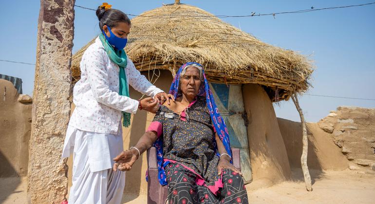 An elderly woman receives a second dose of the COVID vaccine during a  door-to-door campaign in a village in Rajasthan, India.