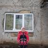2022年2月6日，乌克兰东部一名9岁的女孩站在她家被冲突破坏的外墙前。