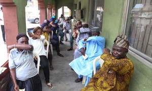 People living in Lagos State in Nigeria, simulate  sneezing into their elbows during a coronavirus prevention campaign. 