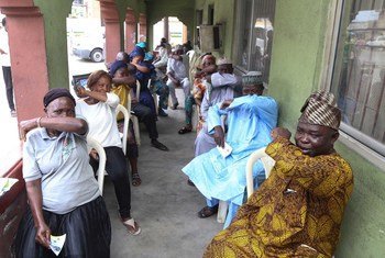 People living in Lagos State in Nigeria, simulate  sneezing into their elbows during a coronavirus prevention campaign. 