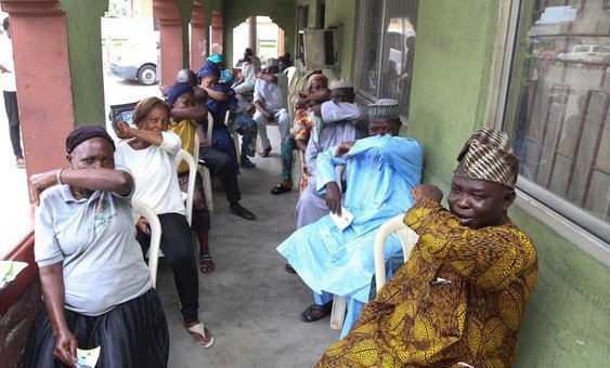People living in Lagos State in Nigeria, simulate  sneezing into their elbows during a coronavirus prevention campaign. 