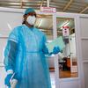在毛里求斯的一个新冠检测诊所，一名卫生工作者穿上了个人防护设备。