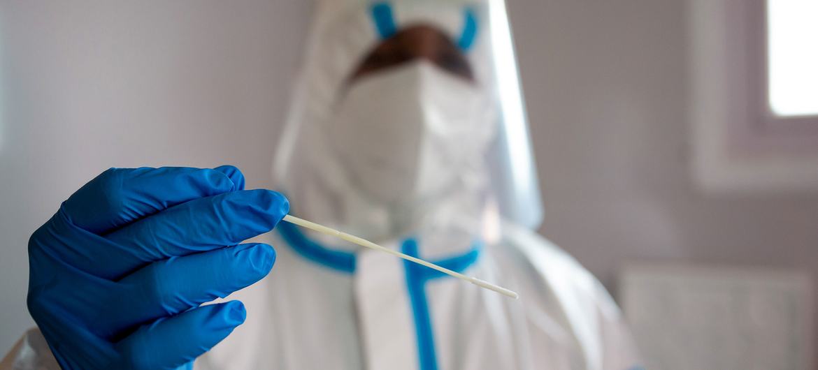 Un agent de santé portant un masque effectue des tests Covid dans une clinique de l'île Maurice.