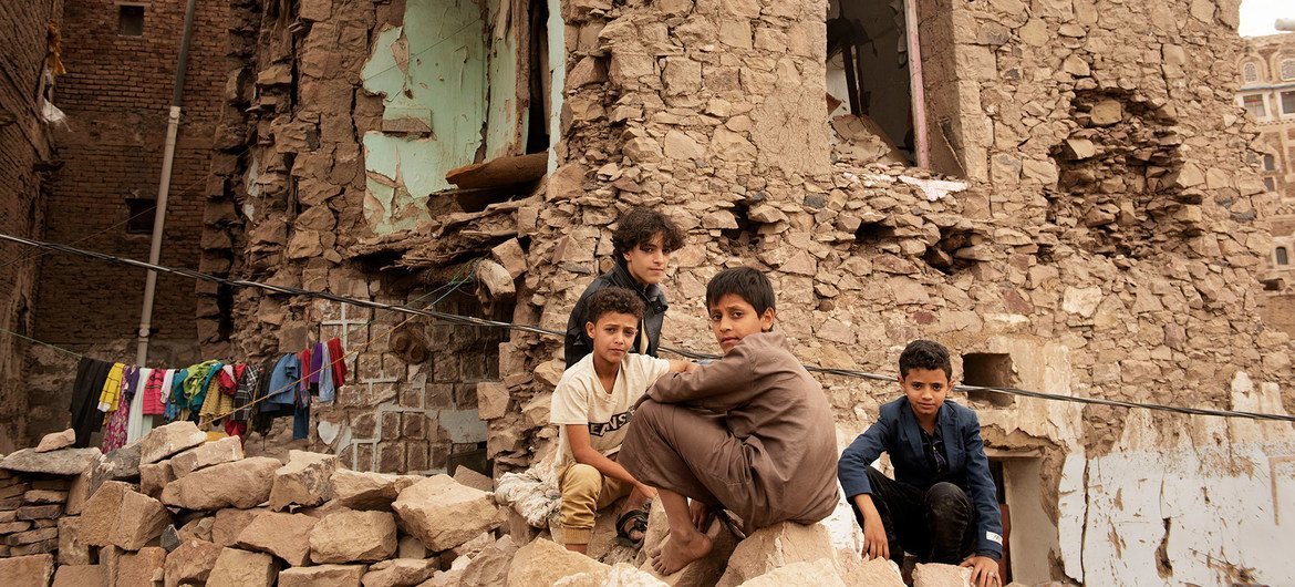 Crianças em frente a uma casa destruída por ataque aéreo em Sanaa.