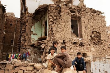 من الأرشيف: أطفال يجلسون أمام منزل دمرته غارة جوية داخل مدينة صنعاء القديمة، اليمن. 