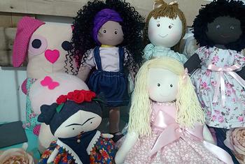 Elas treinam as artesãs em técnicas de produção, empreendedorismo e a venda das bonecas