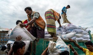 Rohingya refugee workers hand out sacks of rice and lentils at a World Food Programme distribution point in Kutupalong camp, Bangladesh.