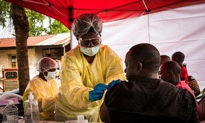 一名卫生工作者在刚果民主共和国东部的贝尼为一名男子接种疫苗。