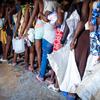 海地太阳城的居民排队领取联合国分发的救援物资。
