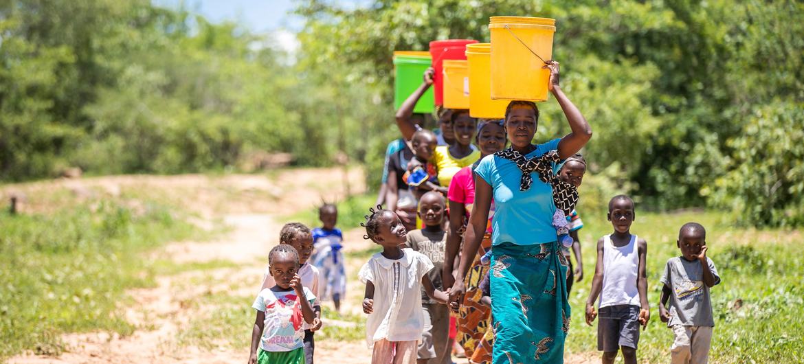 نساء وأطفال يجمعون المياه من بئر أعيد تأهيلها مؤخرا في وادي غويمبي، زامبيا. (صورة من الأرشيف)