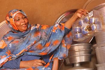 Fatima showcases the wares she trades in through the reintegration cash assistance she received from IOM.