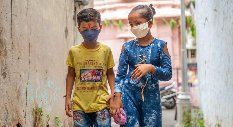 Meninos na Índia se protegem contra Covid-19 usando máscaras faciais.