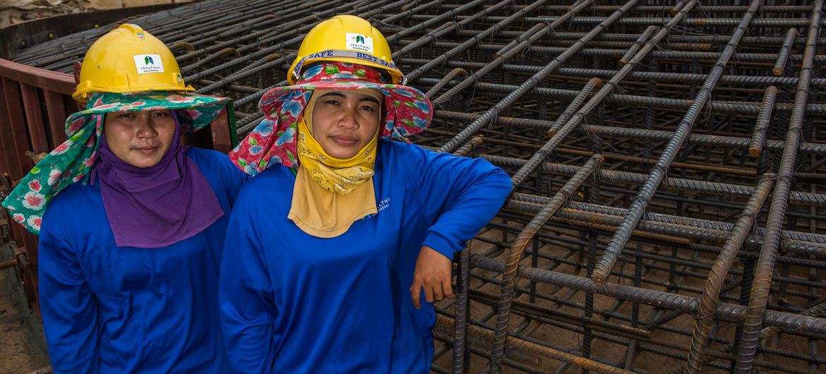थाईलैण्ड में, महिला कामगार, एक पवन ऊर्जा संयंत्र की बुनियाद के निर्माण में सहायता करते हुए.