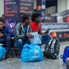 Trois jeunes réfugiés à l'aéroport de Kigali, au Rwanda, après être arrivés de Libye.