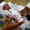 在布基纳法索首都瓦加杜古的一家医院里，一名艾滋病毒呈阳性的妇女正在为她三天大的婴儿接受药物治疗。由于新冠大流行，许多国家的关键艾滋病毒服务已经中断。