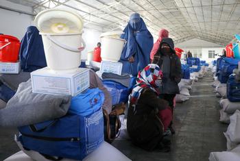 Women and their daughters receive winterization kits from UNICEF in Afghanistan. The kit includes flour, rice, blankets, warm clothes, tarpaulin, and water buckets.