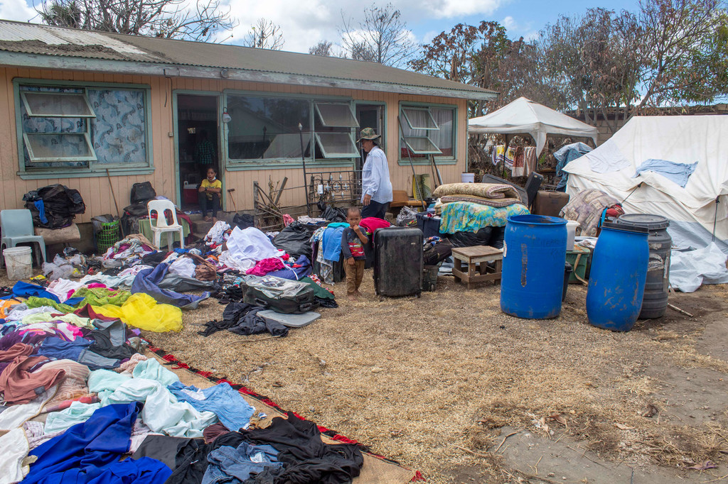 A family dry their belongings outside their home after it was damaged in the Hunga Tonga-Hunga Ha'apai underwater volcano eruption and tsunami.