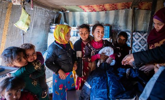 Siblings in their family tent in Alzhouriyeh makeshift camp, east rural Homs, Syria, after receiving their winter clothing kits.