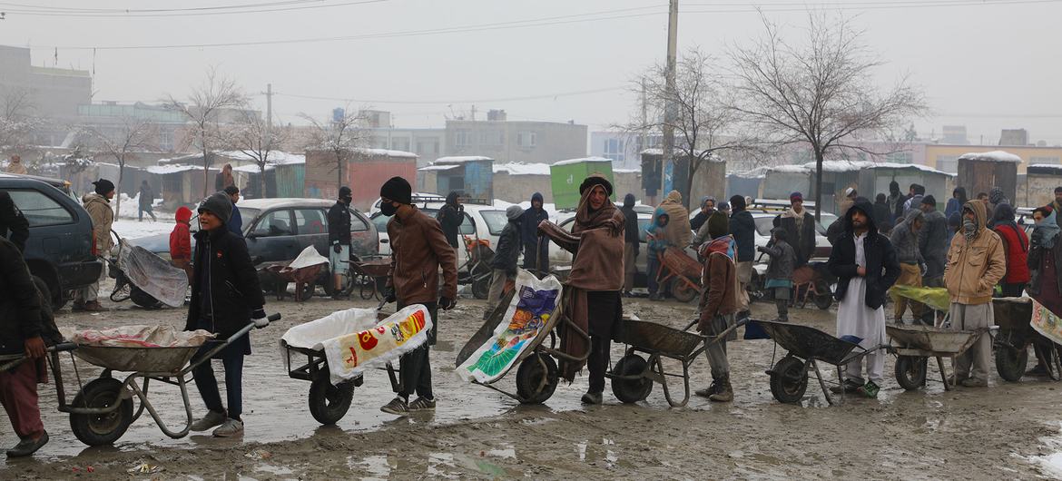 अफ़ग़ानिस्तान की राजधानी काबुल में, लोग संयुक्त राष्ट्र के विश्व खाद्य कार्यक्रम (WFO) से खाद्य सहायता हासिल करने के लिये क़तार में.