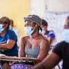 Des femmes écoutent une responsable de l'UNICEF qui explique les bénéfices du vaccin contre la Covid-19 à Port-au-Prince, en Haïti.