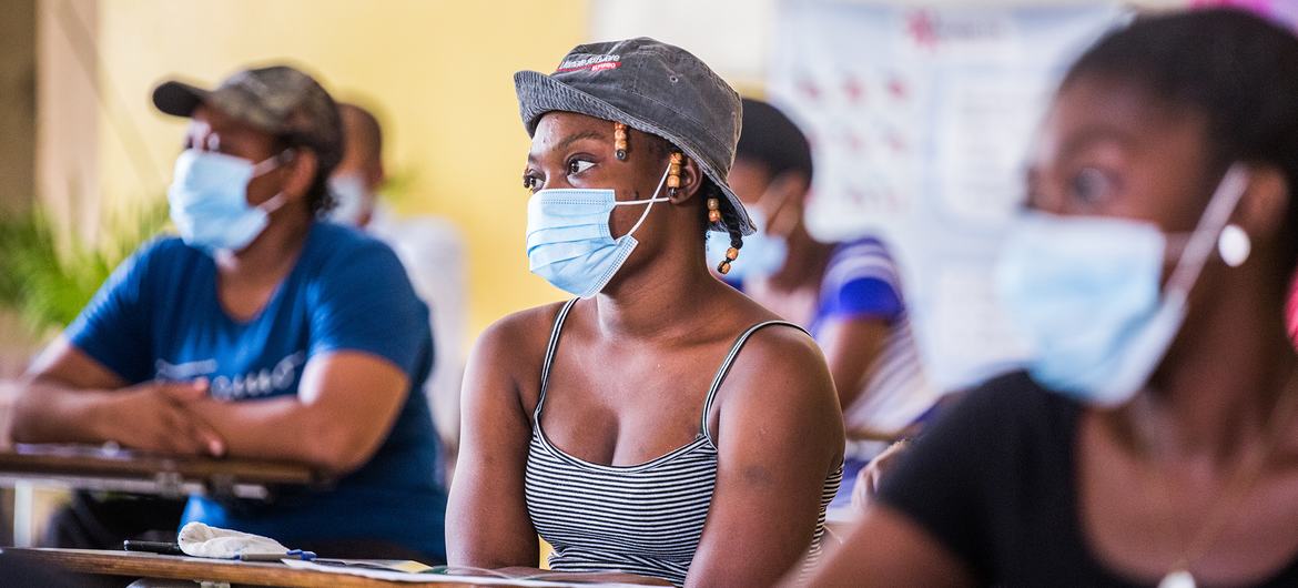 Des femmes écoutent une responsable de l'UNICEF qui explique les bénéfices du vaccin contre la Covid-19 à Port-au-Prince, en Haïti.