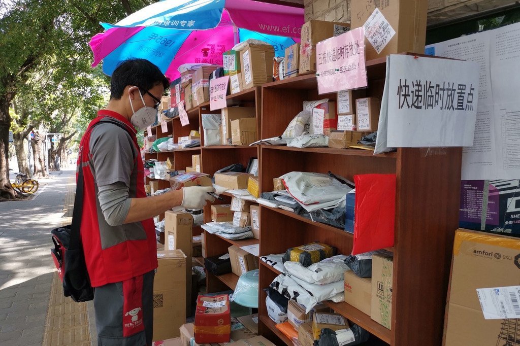 Un homme dépose un paquet à l'extérieur car il n'est pas autorisé à entrer dans les bâtiments pendant l'épidémie de coronavirus en Chine.