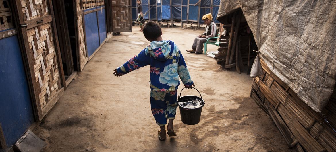 म्याँमार के काचीन प्रान्त में, एक 12 वर्षीय बच्चा, अपने परिवार के लिये , बाल्टी में पानी भर कर ले जाता हुआ. पानी एक बेशक़ीमती प्राकृतिक संसाधन है जिसका सही इस्तेमाल बेहद ज़रूरी है.