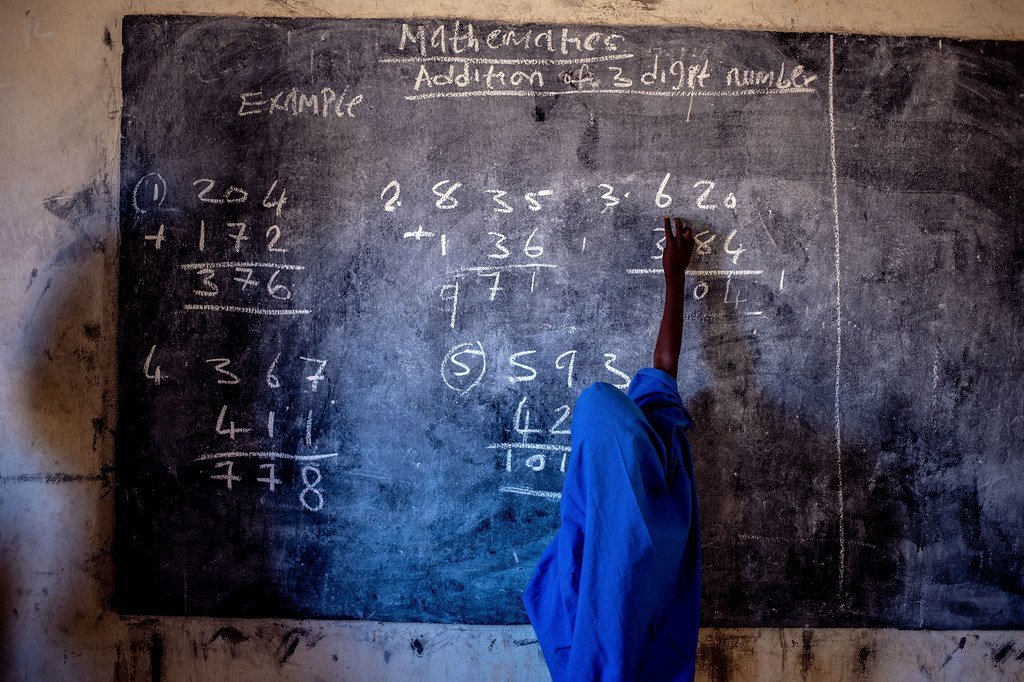Une jeune fille écrit sur un tableau noir dans une école primaire au Nigeria.