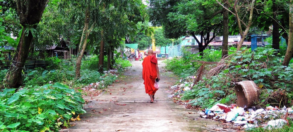 म्याँमार के यंगून शहर में, एक पगोड़ा के निकट से गुज़रता एक बौद्ध सन्त.