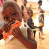 Criança de dois anos come uma pasta nutricional depois de ser testada para desnutrição em Angola