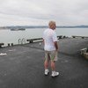 新西兰惠灵顿居民约翰·塞缪尔斯在2019冠状病毒疫情期间站在空旷的码头上