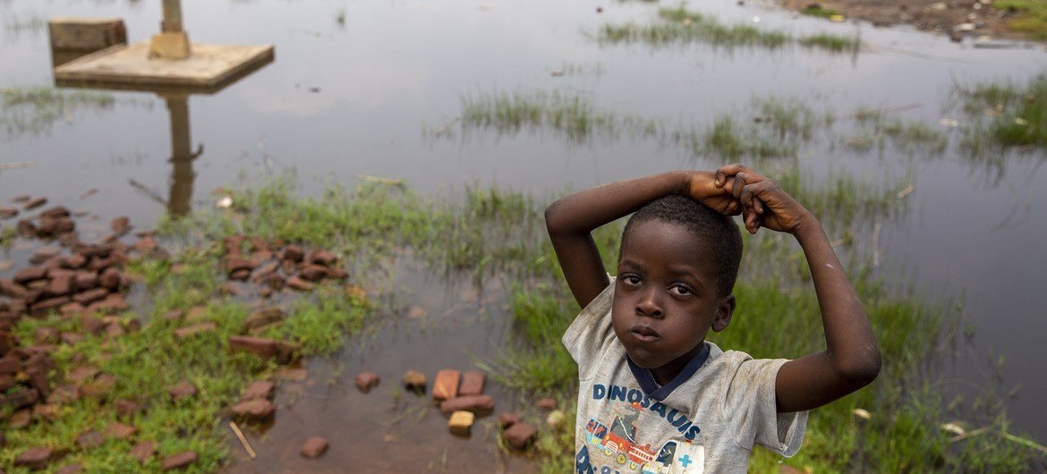  A child stands near a water pump surrounded by floodwaters in Gatumba, located near Bujumbura in Burundi.