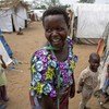 Jeannette Niyibigira, mshoni na mnufaika wa mkopo unaofadhiliwa na UNICEF na shirika la kiraia la Foi en Action akisalimia wakazi wenzake wa kambi ya wakimbizi wa ndani ya Gatumba karibu na mji wa Bujumbura nchini Burundi.