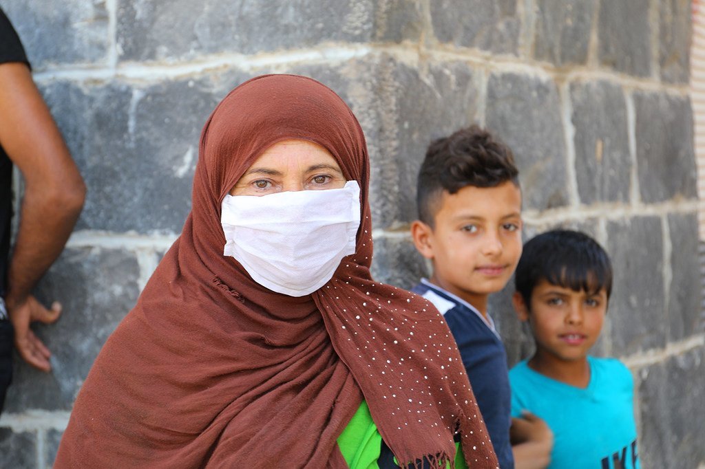 أسر نازحة تنتظر في طوابير للحصول على حصتها الشهرية من الغذاء في دمشق بسوريا.