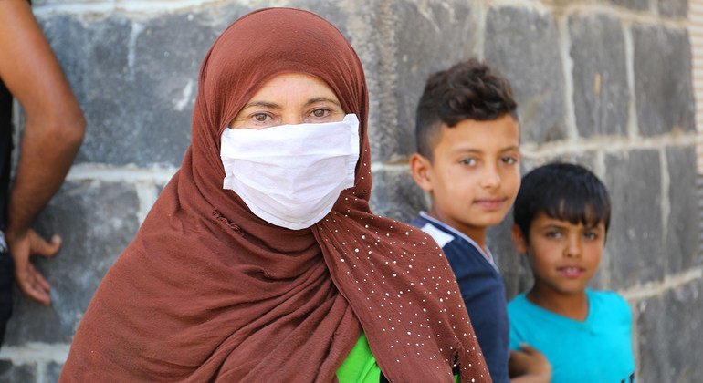 Displaced families wait in line for monthly food rations in Damascus, Syria.