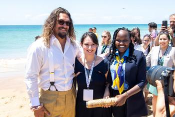 El actor y defensor de los océanos Jason Momoa (izquierda) se reúne con jóvenes defensores de los océanos en la playa de Carcavelos, en Lisboa (Portugal), durante la Cumbre de los Océanos de la ONU.