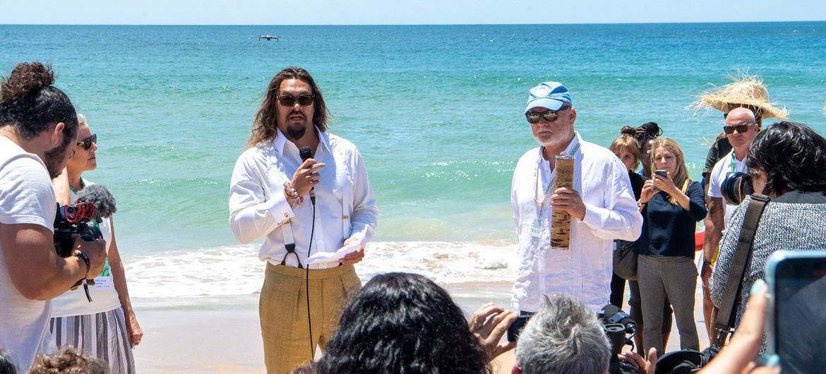 الممثل ومناصر المحيطات جيسون موموا (يسار) ومبعوث الأمم المتحدة للمحيطات بيتر طومسون (يمين) على شاطئ كاركافيلوس في لشبونة، البرتغال، خلال فعالية تسليم "عصا الطبيعة" على هامش مؤتمر الأمم المتحدة للمحيط.