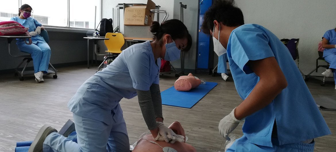 Nursing students perform cardiopulmonary resuscitation on a manikin.